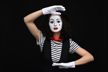 Young woman in mime costume posing on black background - 761614880