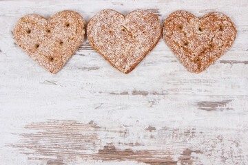 Fresh homemade wholegrain bread in shape of heart for breakfast. Copy space for text on old rustic background