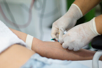 Doctora sacando muestras de sangre del brazo para un análisis de sangre,evaluación paciente - obrazy, fototapety, plakaty