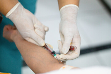 Doctora sacando muestras de sangre del brazo para un análisis de sangre,evaluación paciente,salud - obrazy, fototapety, plakaty