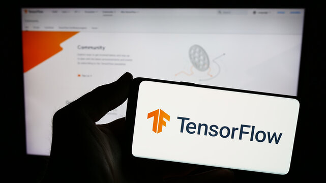 Stuttgart, Germany - 03-08-2024: Person holding smartphone with logo of open-source software library TensorFlow in front of website. Focus on phone display.