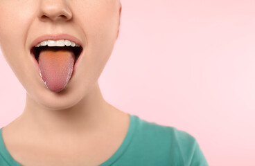 Gastrointestinal diseases. Woman showing her yellow tongue on pink background, closeup. Space for text