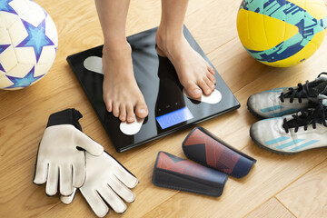 Kid or child feet on a weight scale concept suggesting being active - 761623676