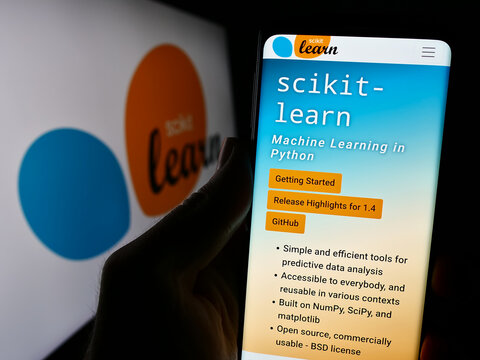 Stuttgart, Germany - 03-08-2024: Person holding cellphone with webpage of software machine learning library scikit-learn in front of logo. Focus on center of phone display.