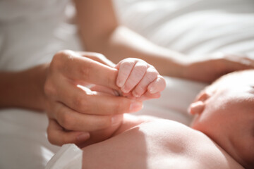 Obraz na płótnie Canvas Mother with her newborn baby, closeup on hands