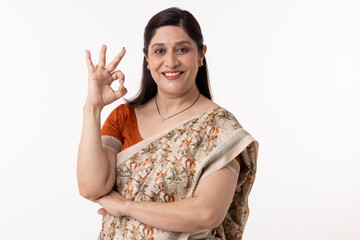 Smiling indian woman in sari posing at white background