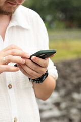 A man surfs the Internet, searching for information on the Internet. A man touches the phone screen with his finger. Scroll the web. Communication via smartphone.