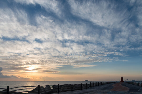 View of the sunrise over the seawall in the cloudy morning © 안구정화