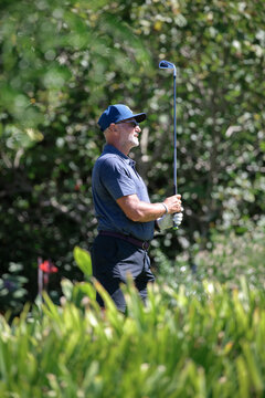 A male golfer swinging his club.