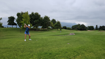 Female golf player swinging golf club concept