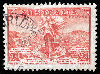 Ukraine, Kiyiv - February 3, 2024.Postage stamps from Australia.A Stamp printed in AUSTRALIA shows the Amphitrite, joining Cables between Australia and Tasmania, circa 1936 - obrazy, fototapety, plakaty