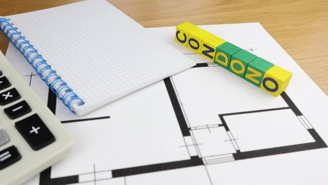 Single word condone on wooden block, tax amnesty taxes, with an office desk background.