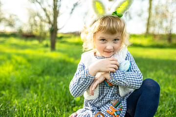 Happy little girl, with Bunny ears, radiates laughter against the backdrop of a vibrant garden on...