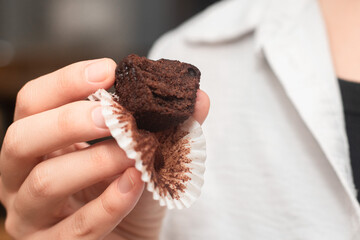 Hand Holding Chocolate Muffins. Presenting freshly baked chocolate muffins.