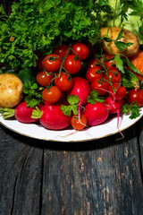 plate with fresh seasonal vegetables on a wooden background, vertical
