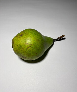One sweet delicious juicy green pear lies on a white background