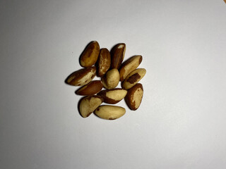 A peeled Brazil nut lies in a pile on a white background. Healthy and delicious