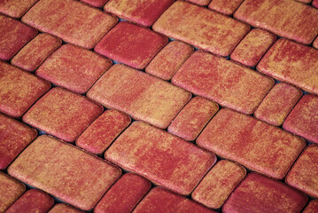 A collection of concrete sidewalk pavers in various shades of orange, ideal for creating a natural and organic look in outdoor areas.