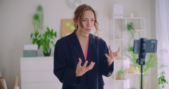 Female content creator vlogging through mobile phone on tripod