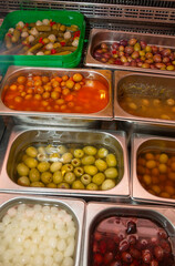 Containers full of olives and pickles. Window display of a shop selling Spanish olives