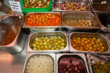Containers full of olives and pickles. Window display of a shop selling Spanish olives