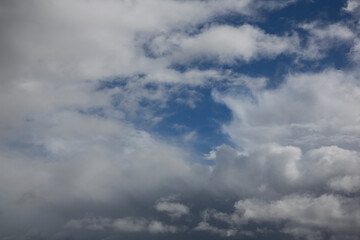 Cloudy sky with white clouds and a cloudless area with blue sky
