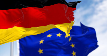 Flags of Germany and the European Union waving in the wind on a clear day