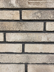 The wall is lined with decorative stone, beautiful seams, background. For the facade of the house, fence