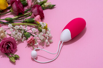 Vibrator adult toy with delicate flowers on a pink backdrop