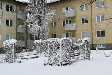 Snow-covered residential building with trees