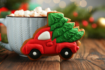 Tasty Christmas cookie in shape of car with fir tree and cocoa with marshmallows on wooden table,...