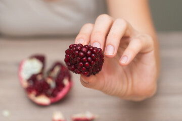 Female Hands Holding Open Pomegranate. Cradling a freshly opened pomegranate revealing juicy seeds.