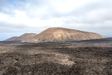 View over multiple small volcanoes among vast lava fields in Timanfaya National park, Lanzarote, Canary islands