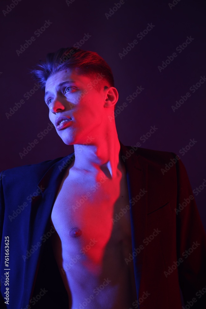 Poster Sexy young man on dark background in neon lights