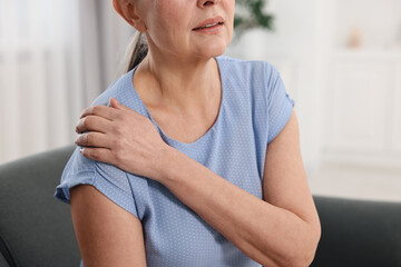 Arthritis symptoms. Woman suffering from pain in shoulder at home