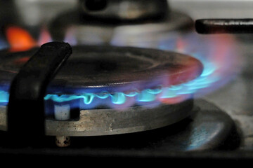 Flames on gas hob, kitchen gas cooker with burning fire propane gas