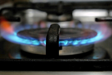 Flames on gas hob, kitchen gas cooker with burning fire propane gas