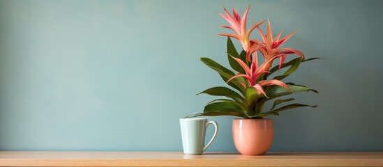 A houseplant in a flowerpot sits on a wooden table next to a cup, bringing a touch of nature indoors with its green foliage and beautiful blooms