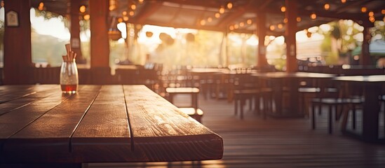 A wooden table with a pint of beer rests in a restaurant, illuminated by the soft light filtering through the window. The hardwood fixture adds warmth to the room - obrazy, fototapety, plakaty