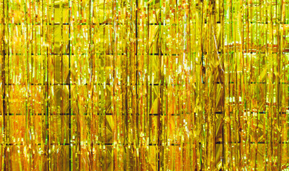 Festive background of shiny gold metallic tinsel strands,gold foil decoration, abstract party decoration background