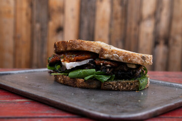 Vegetarian sandwich. Closeup view of a fresh sandwich with arugula, sun dried tomatoes, brie cheese...