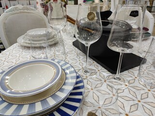 Table set, porcelain plates, wineglasses, table cloth prepared for celebration