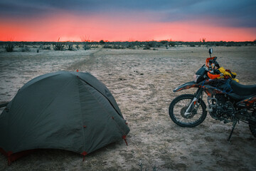 motorcycle camping tent at sunset in desert landscape 