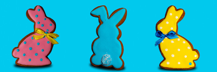 Bunny shaped cookies on pastel blue background. Easter gingerbread cookie.