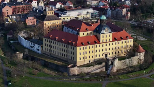 Flight to Moritzburg Castle in Zeitz. Telephoto shot of the castle and moat. Slow flight around the north side of the castle. Parts of the building illuminated by the sun.