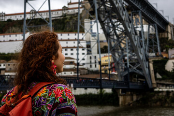 Woman looking at the iron bridge that crosses the Douro River in Porto