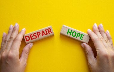 Despair or Hope symbol. Concept word Despair or Hope on wooden blocks. Businessman hand. Beautiful yellow background. Business and Despair or Hope concept. Copy space