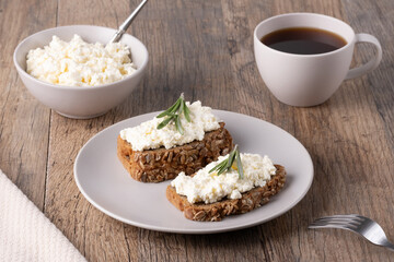 Homemade rye bread with cottage cheese in a plate and coffee. Healthy breakfast concept