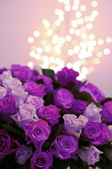 Bouquet of violet roses against blurred background, closeup. Funeral attributes