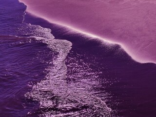 Sea purple waves on the beach at evening.